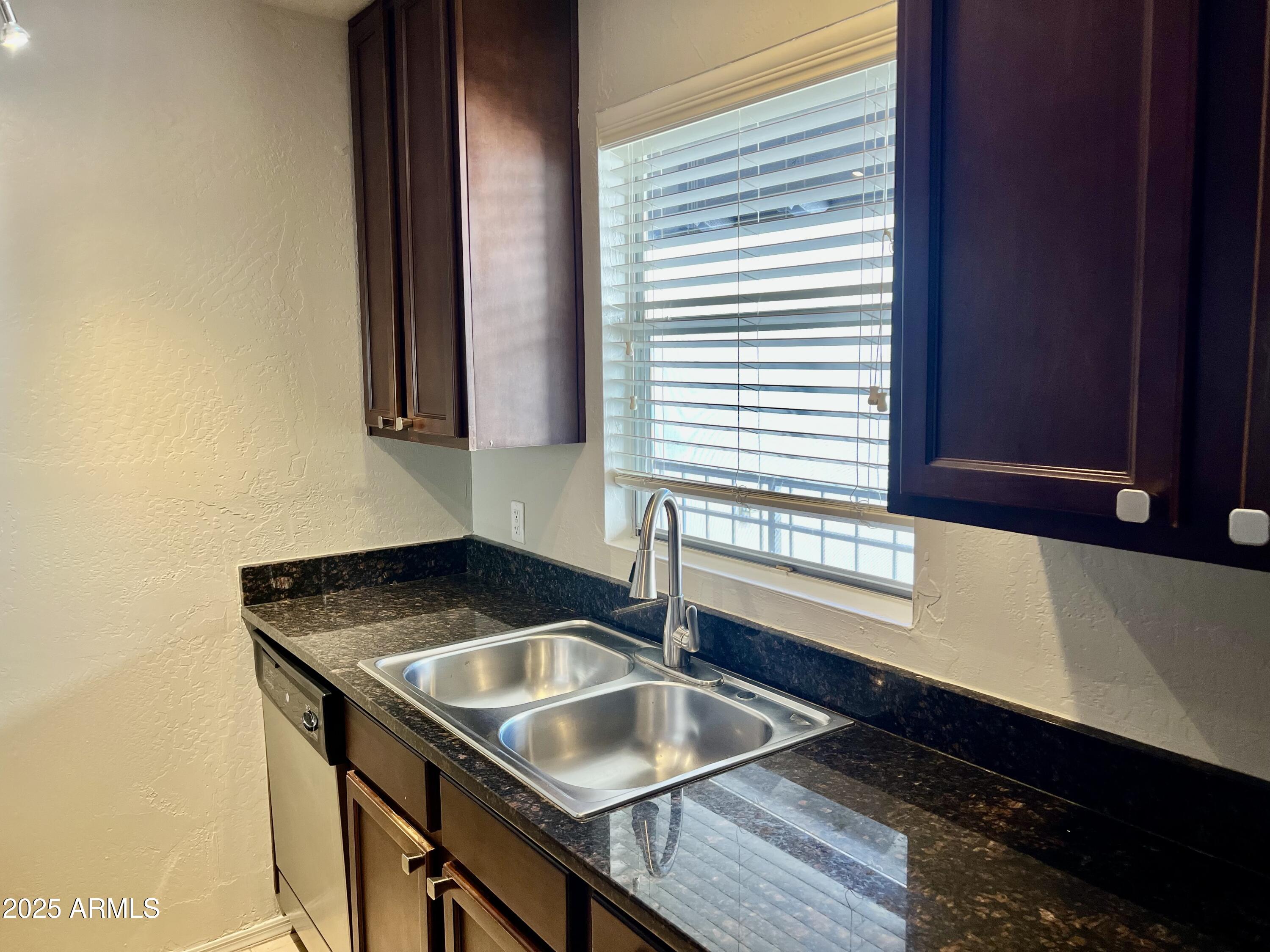 14145 North 92nd Street, Unit 2101 Scottsdale, AZ 85260 - Photo 8 of 30 a kitchen with granite countertop a sink and a granite counter tops