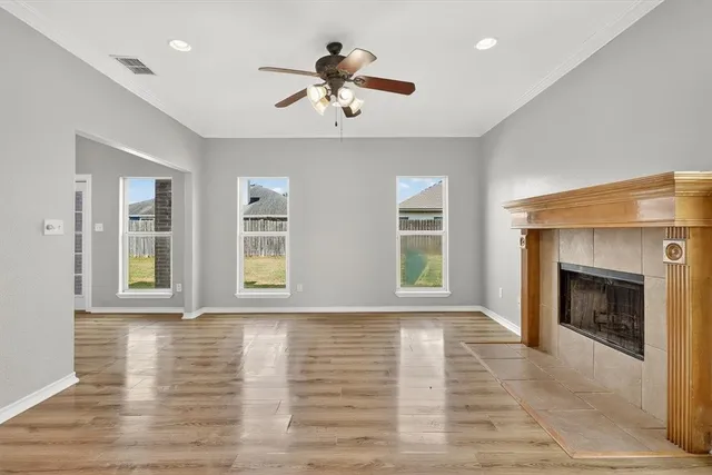 a view of an empty room with window and fire place
