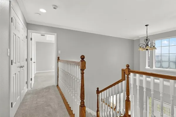 a view of a hallway with a window and wooden floor
