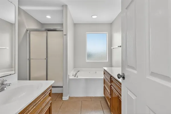 a bathroom with a tub sink and mirror