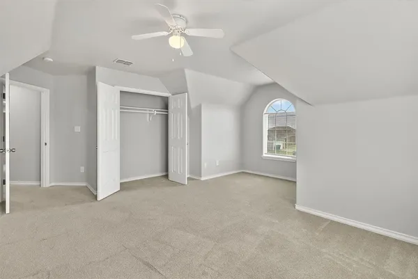 an empty room with a ceiling fan and a window