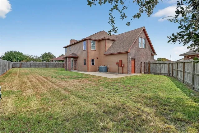 a view of a house with backyard and a tree