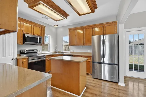 a kitchen with stainless steel appliances granite countertop a refrigerator stove top oven and sink