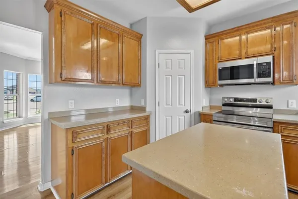 a kitchen with stainless steel appliances granite countertop a stove microwave and cabinets