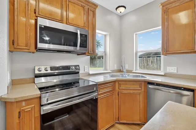 a kitchen with stainless steel appliances a stove microwave and sink