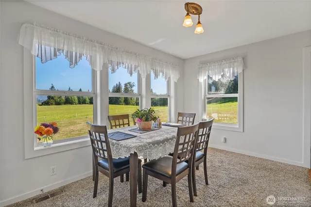a dining room with furniture a flat screen tv and a large window