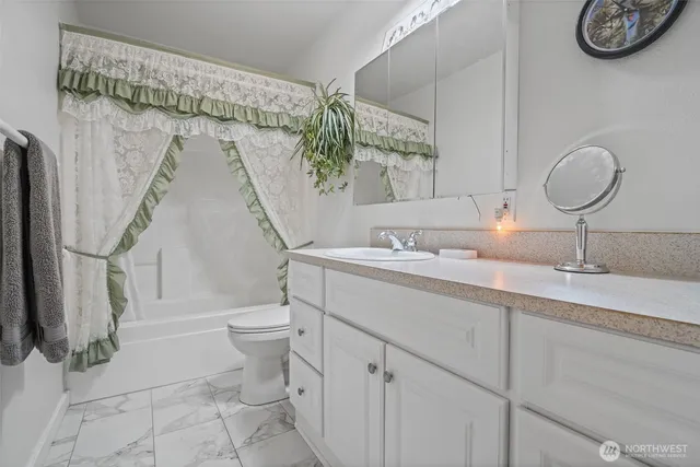 a bathroom with a sink a toilet and a mirror