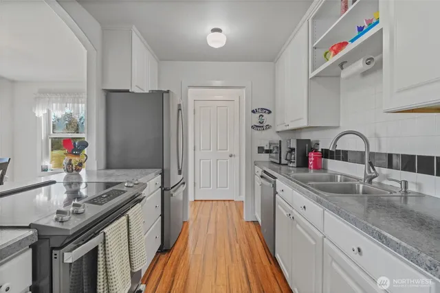 a kitchen with stainless steel appliances granite countertop a sink stove and refrigerator