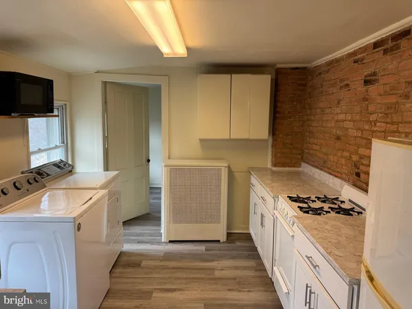 a kitchen with granite countertop a sink stove and refrigerator