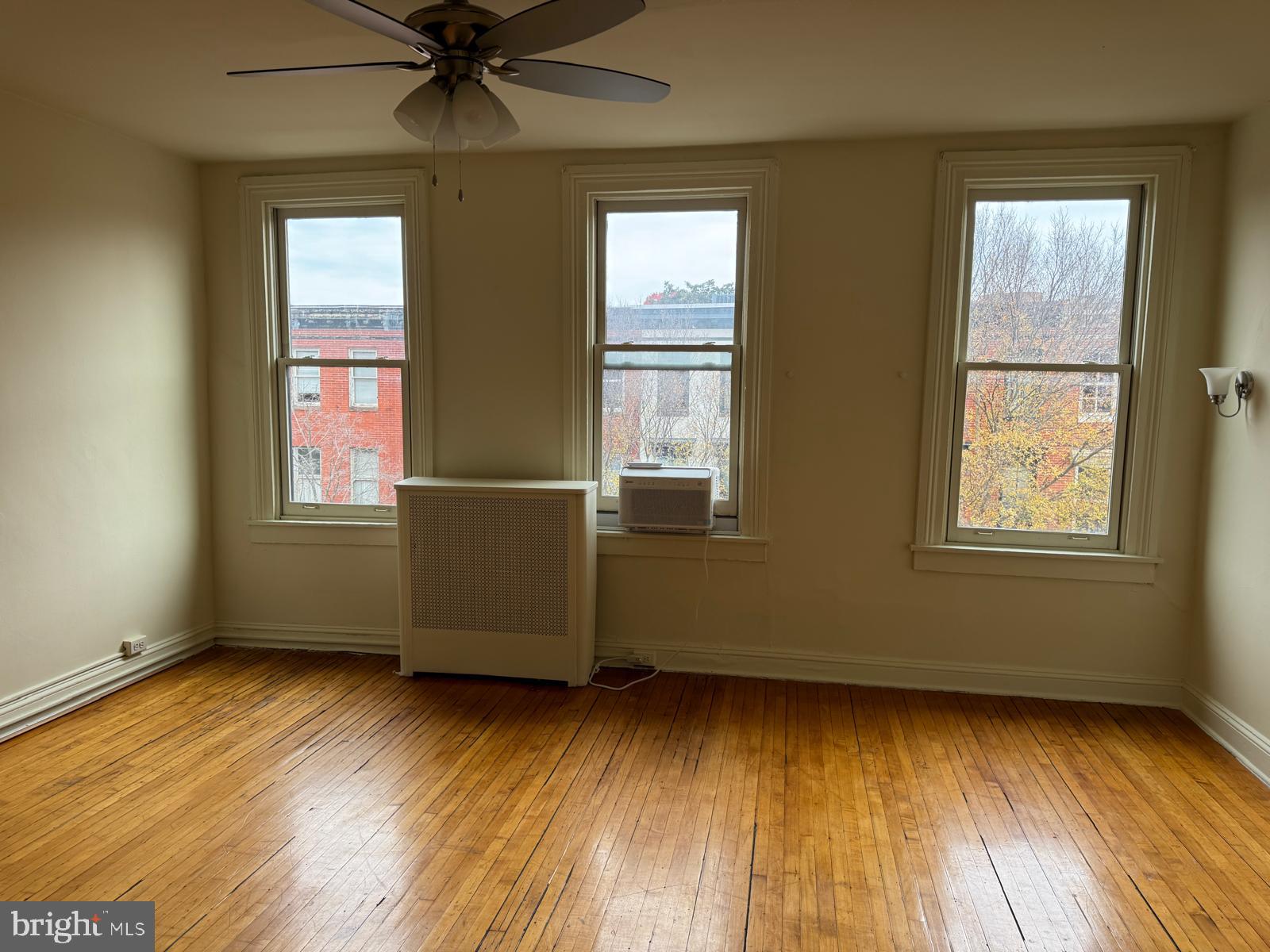 230 West Lafayette Avenue, Unit 3 Baltimore, MD 21217 - Photo 4 of 19 a view of an empty room with wooden floor and a window