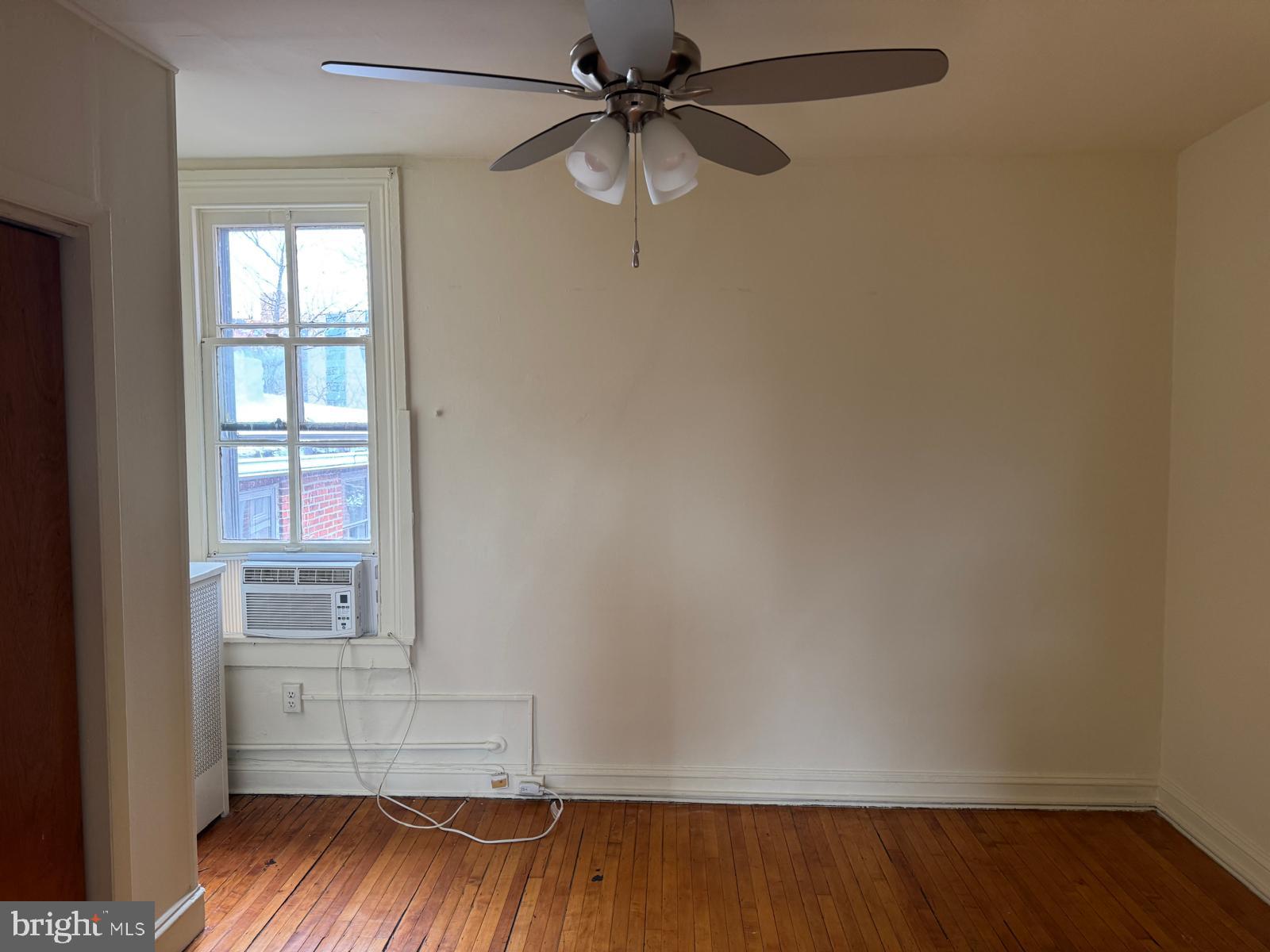 230 West Lafayette Avenue, Unit 3 Baltimore, MD 21217 - Photo 8 of 19 an empty room with a window and wooden floor