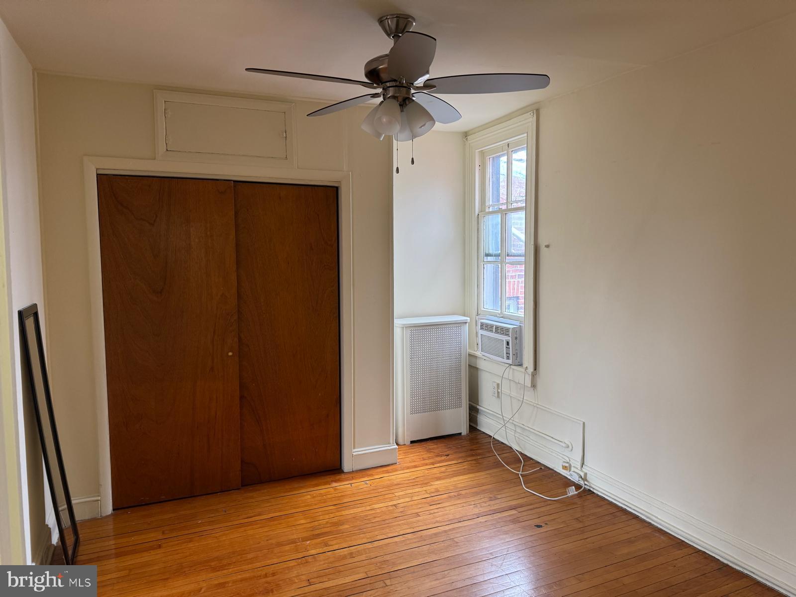 230 West Lafayette Avenue, Unit 3 Baltimore, MD 21217 - Photo 9 of 19 an empty room with wooden floor and a ceiling fan