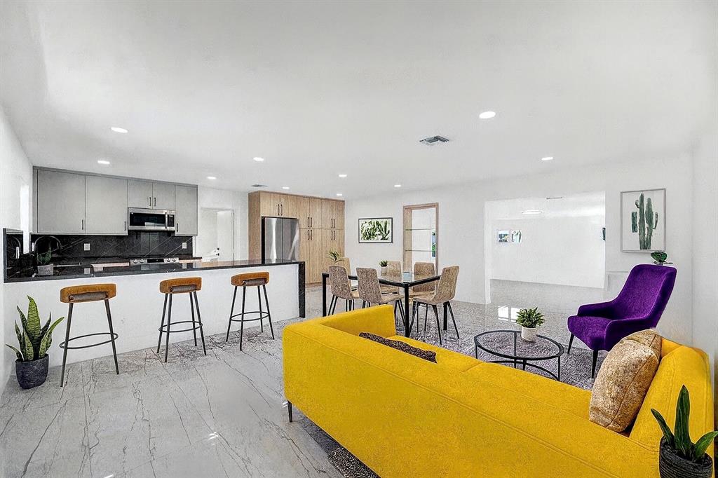 121 Southeast 8th Street Pompano Beach, FL 33060 - Photo 13 of 14 a living room with furniture a wooden floor and kitchen view