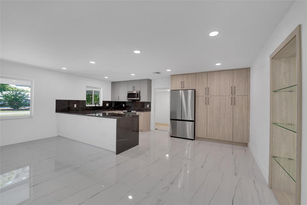 121 Southeast 8th Street Pompano Beach, FL 33060 - Photo 3 of 14 a kitchen with a refrigerator and a stove top oven