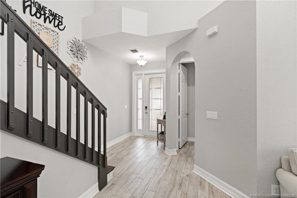1268 Southeast Kirk Street Stuart, FL 34997 - Photo 14 of 63 a view of a hallway with wooden floor and staircase