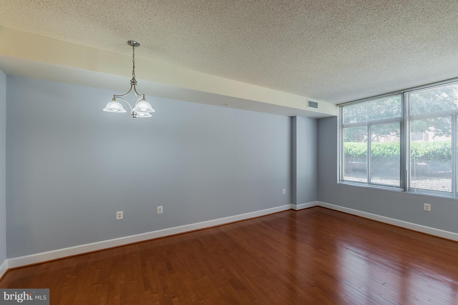 3600 South Glebe Road, Unit 227W Arlington, VA 22202 - Photo 11 of 29 an empty room with wooden floor and windows
