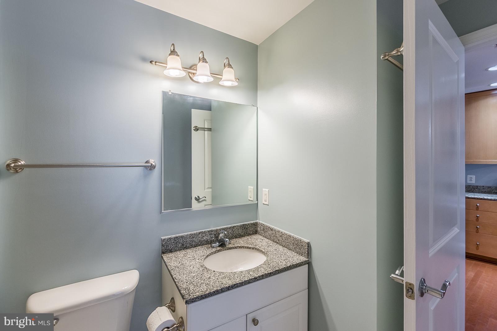 3600 South Glebe Road, Unit 227W Arlington, VA 22202 - Photo 18 of 29 a bathroom with a granite countertop sink a toilet and a mirror