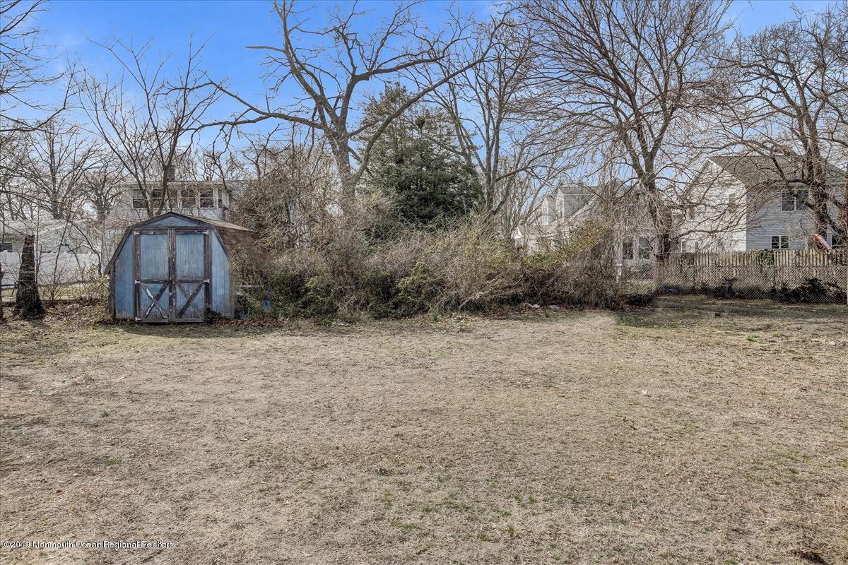 6 Bash Road Toms River, NJ 08753 - Photo 17 of 19 a backyard of a house with large trees and wooden fence