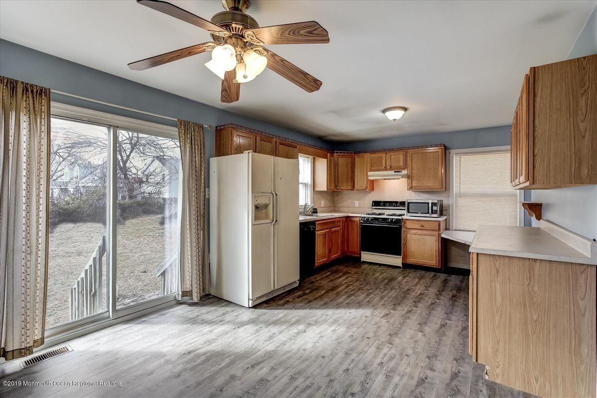 6 Bash Road Toms River, NJ 08753 - Photo 7 of 19 a kitchen with stainless steel appliances granite countertop a refrigerator a sink dishwasher a stove and a dining table with wooden floor