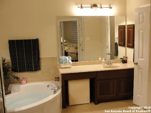 a bathroom with a tub sink and mirror