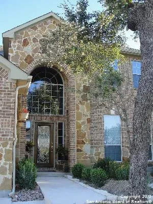 a front view of a house with a tree