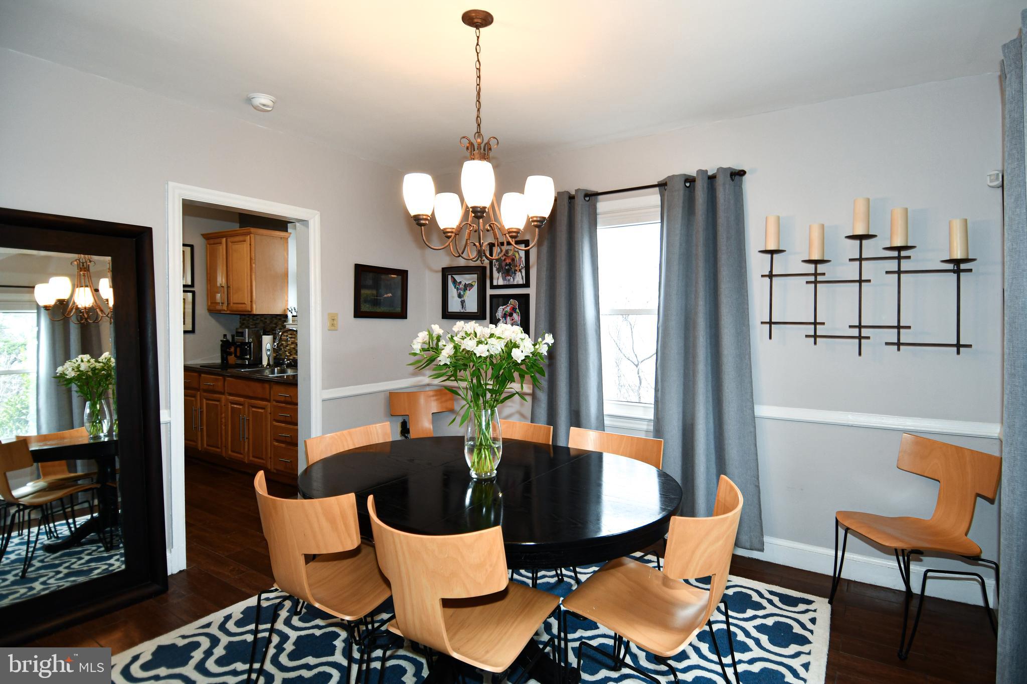 6208 Sligo Mill Road Northeast Washington, DC 20011 - Photo 17 of 50 a dining room with furniture a chandelier and wooden floor