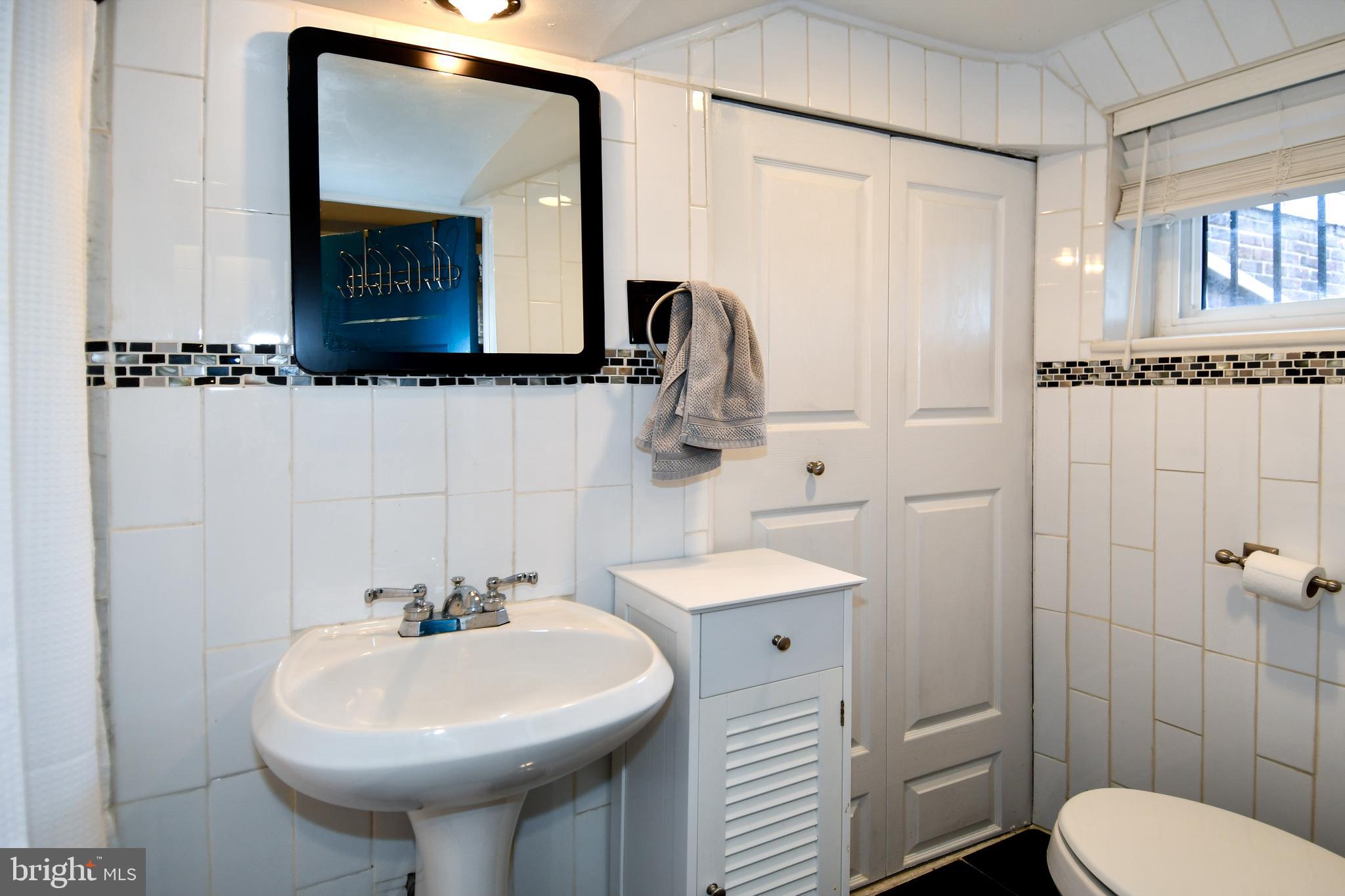 6208 Sligo Mill Road Northeast Washington, DC 20011 - Photo 38 of 50 a bathroom with a toilet sink and mirror