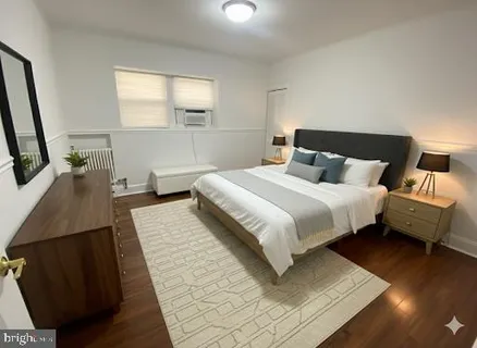 a bedroom with a bed a mirror and window
