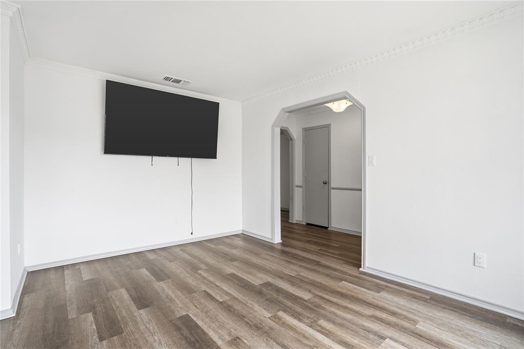 4612 Applewood Road Fort Worth, TX 76133 - Photo 19 of 39 Unfurnished room with arched walkways, wood finished floors, and ornamental molding