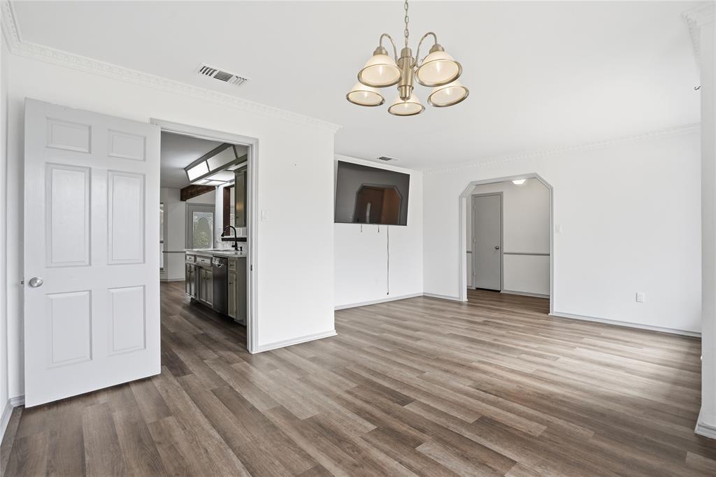 4612 Applewood Road Fort Worth, TX 76133 - Photo 21 of 39 Unfurnished dining area featuring crown molding, a chandelier, dark wood-style floors, and arched walkways