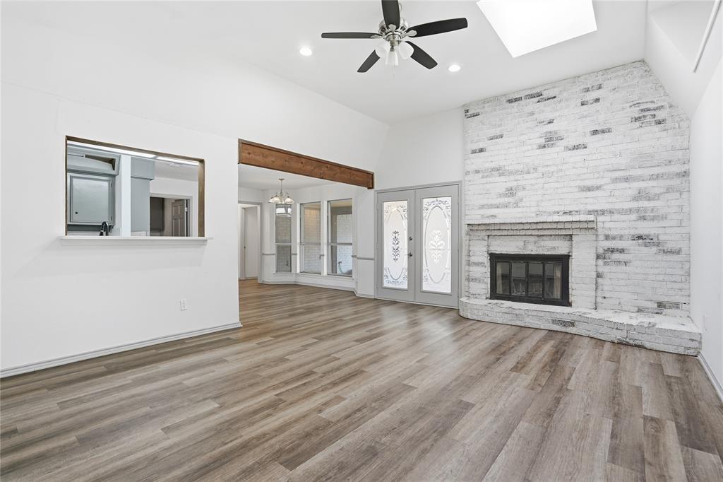 4612 Applewood Road Fort Worth, TX 76133 - Photo 22 of 39 Unfurnished living room with light wood-style floors, high vaulted ceiling, a skylight, ceiling fan, and french doors