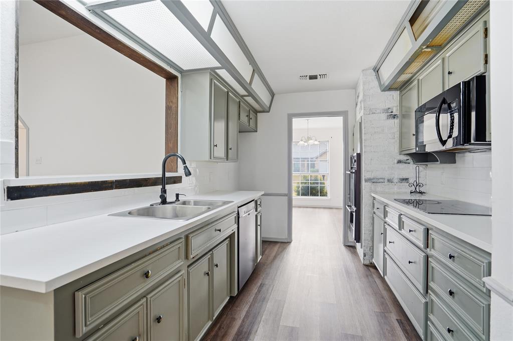 4612 Applewood Road Fort Worth, TX 76133 - Photo 27 of 39 Kitchen featuring light countertops, black appliances, dark wood-style floors, and gray cabinets