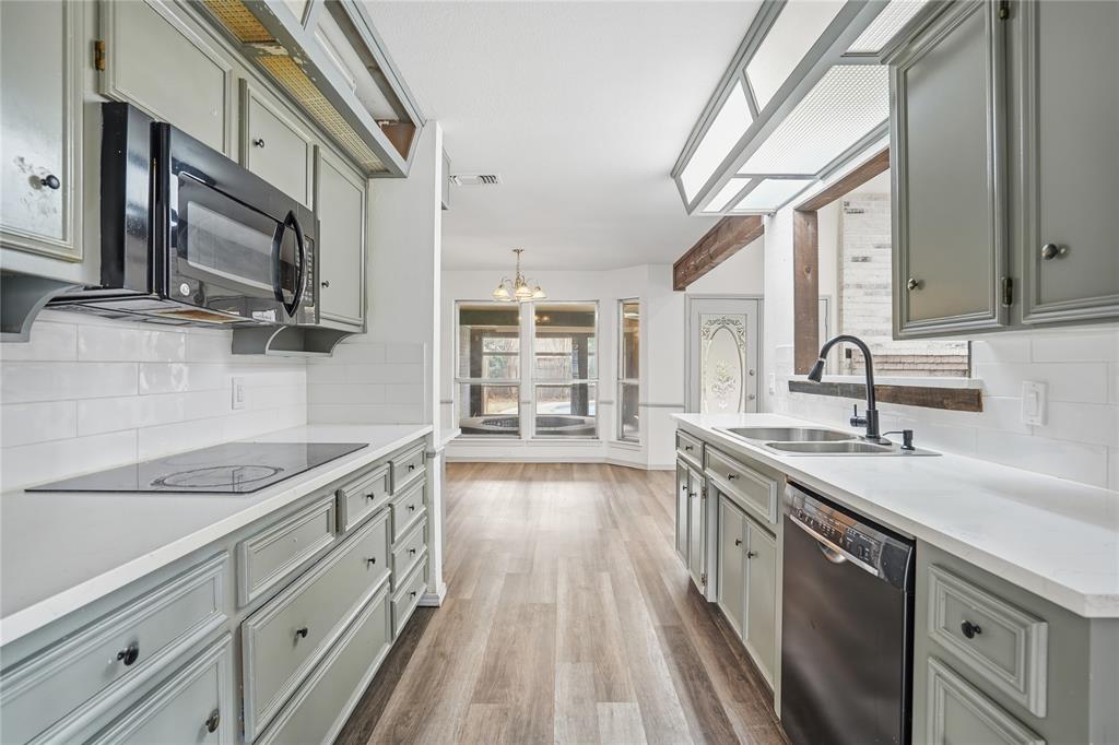 4612 Applewood Road Fort Worth, TX 76133 - Photo 28 of 39 Kitchen featuring tasteful backsplash, black appliances, dark wood-type flooring, and a chandelier