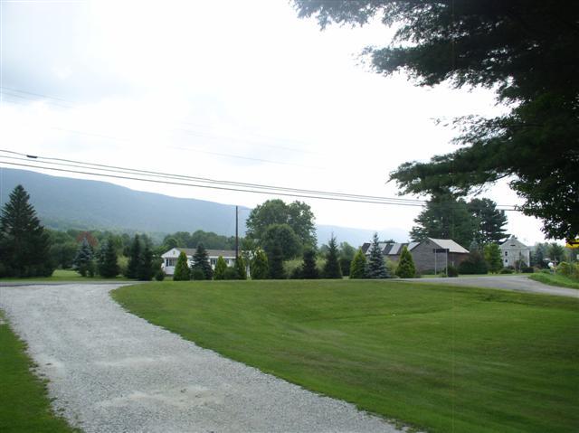 493 Main Road Stamford, VT 05352 - Photo 24 of 24 a view of a grassy field with an trees