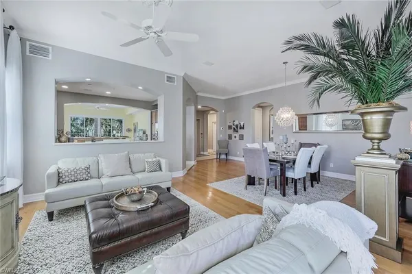 a living room with furniture kitchen view and a potted plant