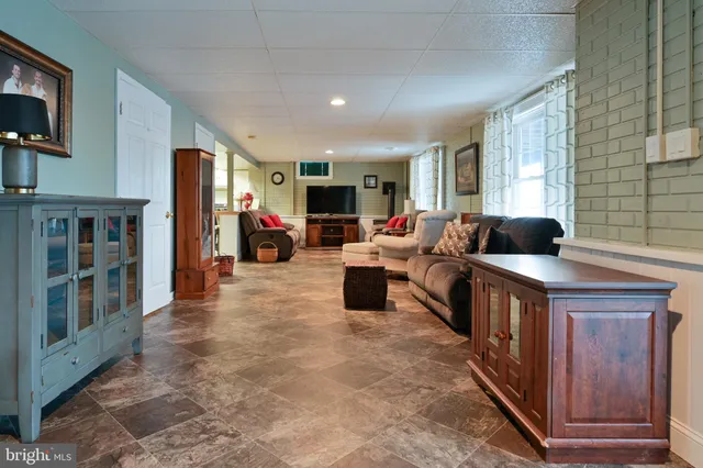 a living room with stainless steel appliances furniture a rug kitchen view and a dining table
