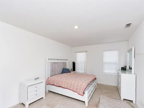 a bedroom with a large bed and a window