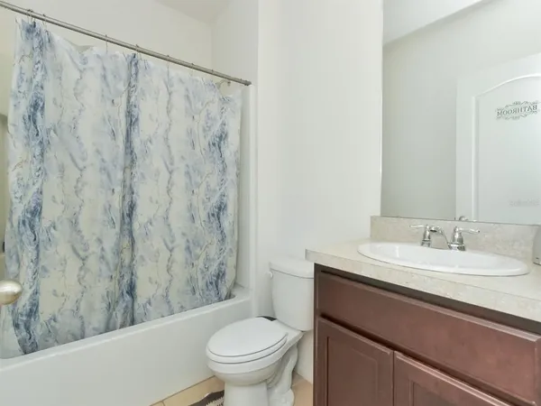 a bathroom with a granite countertop sink and a toilet