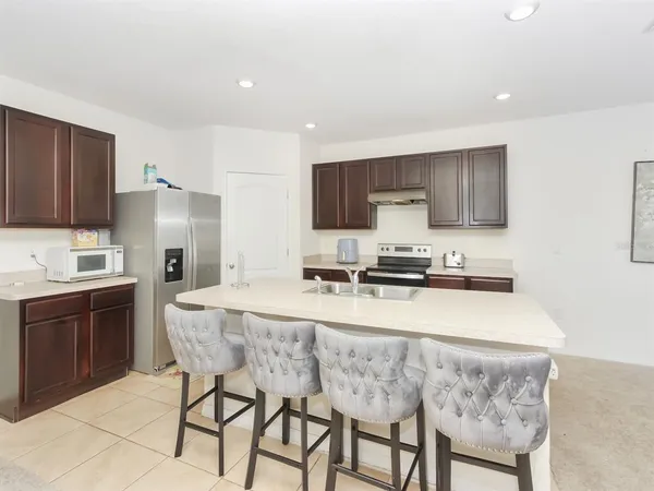 a kitchen with kitchen island granite countertop a sink stove and refrigerator