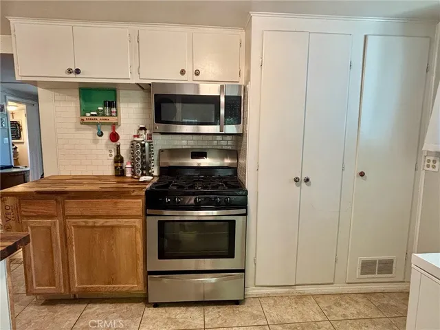 a kitchen with stainless steel appliances white cabinets and a stove top oven