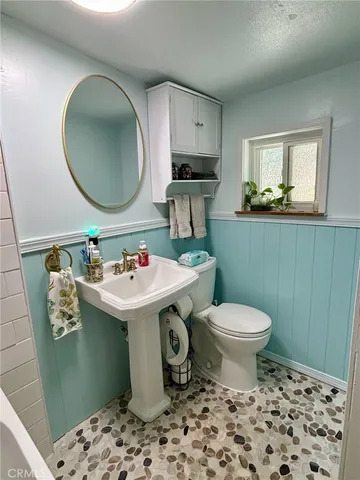 a bathroom with a sink toilet and mirror