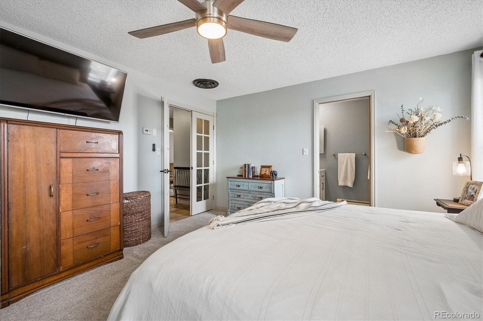 4654 South Union Street Morrison, CO 80465 - Photo 14 of 34 a bedroom with a large bed and a chandelier
