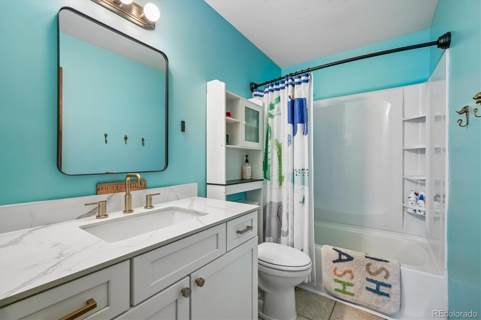4654 South Union Street Morrison, CO 80465 - Photo 20 of 34 a bathroom with a granite countertop sink toilet and shower