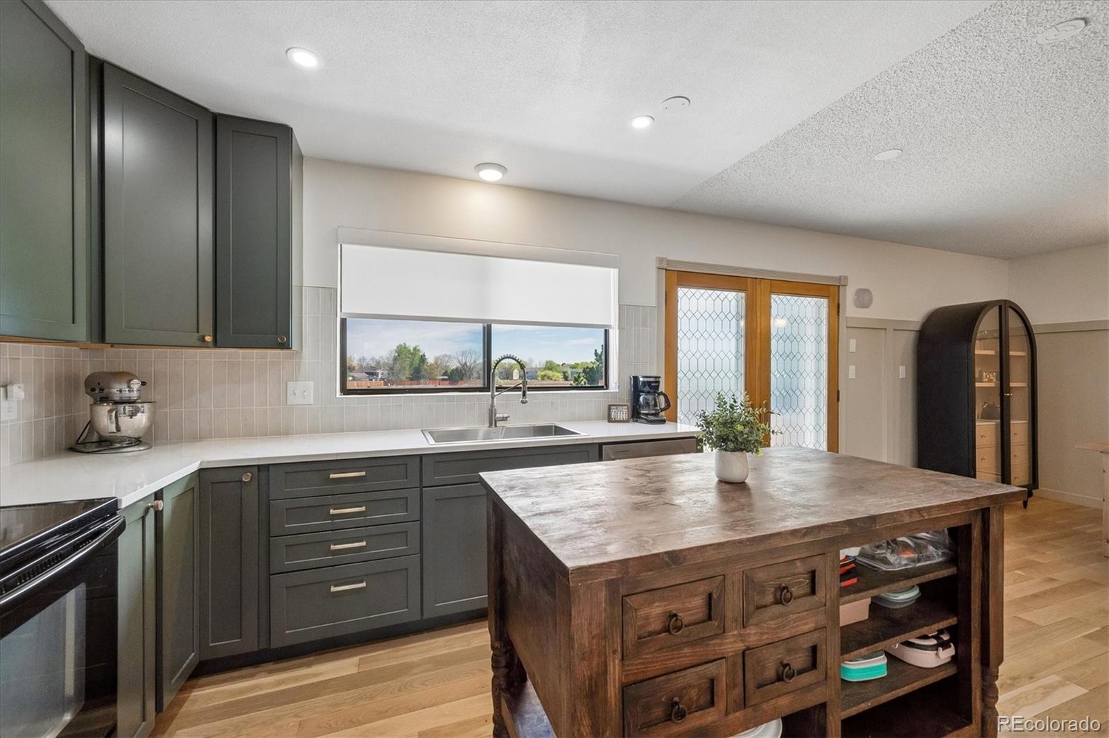 4654 South Union Street Morrison, CO 80465 - Photo 7 of 34 a kitchen with a stove a sink and a wooden cabinets