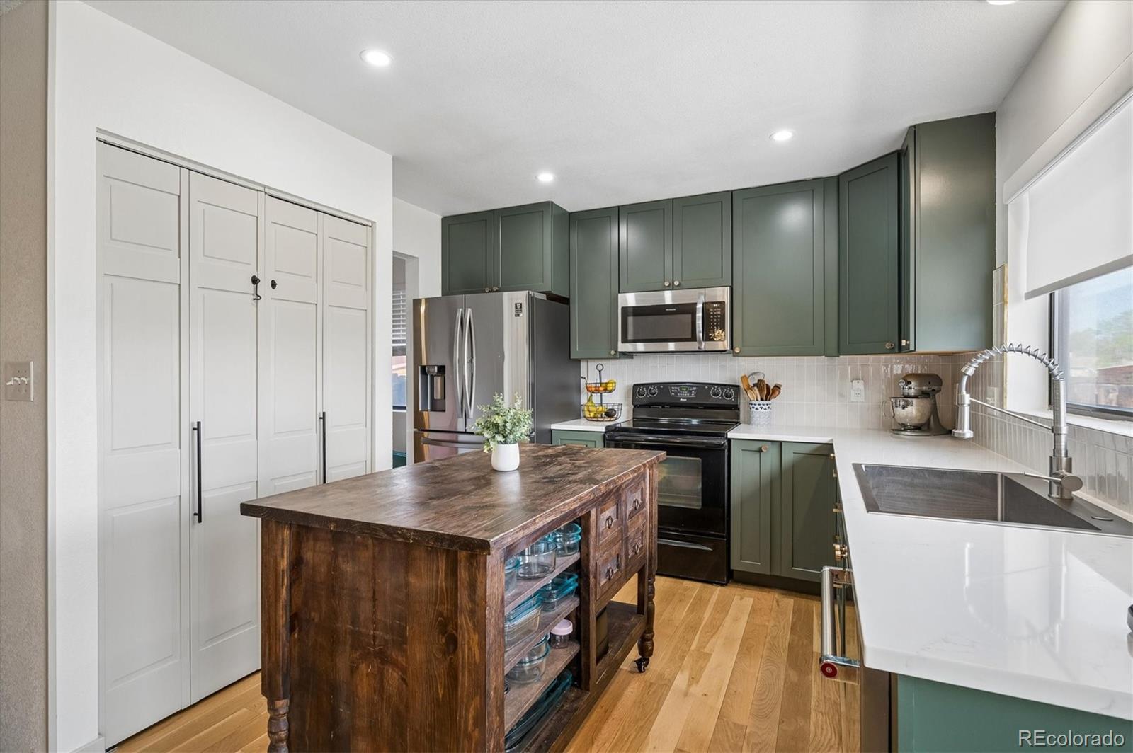 4654 South Union Street Morrison, CO 80465 - Photo 8 of 34 a kitchen with refrigerator cabinets and wooden floor