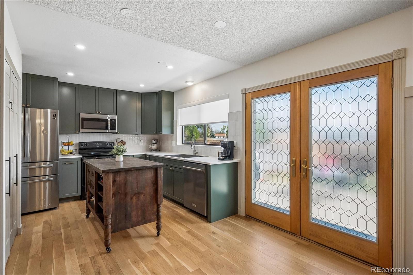 4654 South Union Street Morrison, CO 80465 - Photo 9 of 34 a kitchen with stainless steel appliances granite countertop a refrigerator and a stove top oven