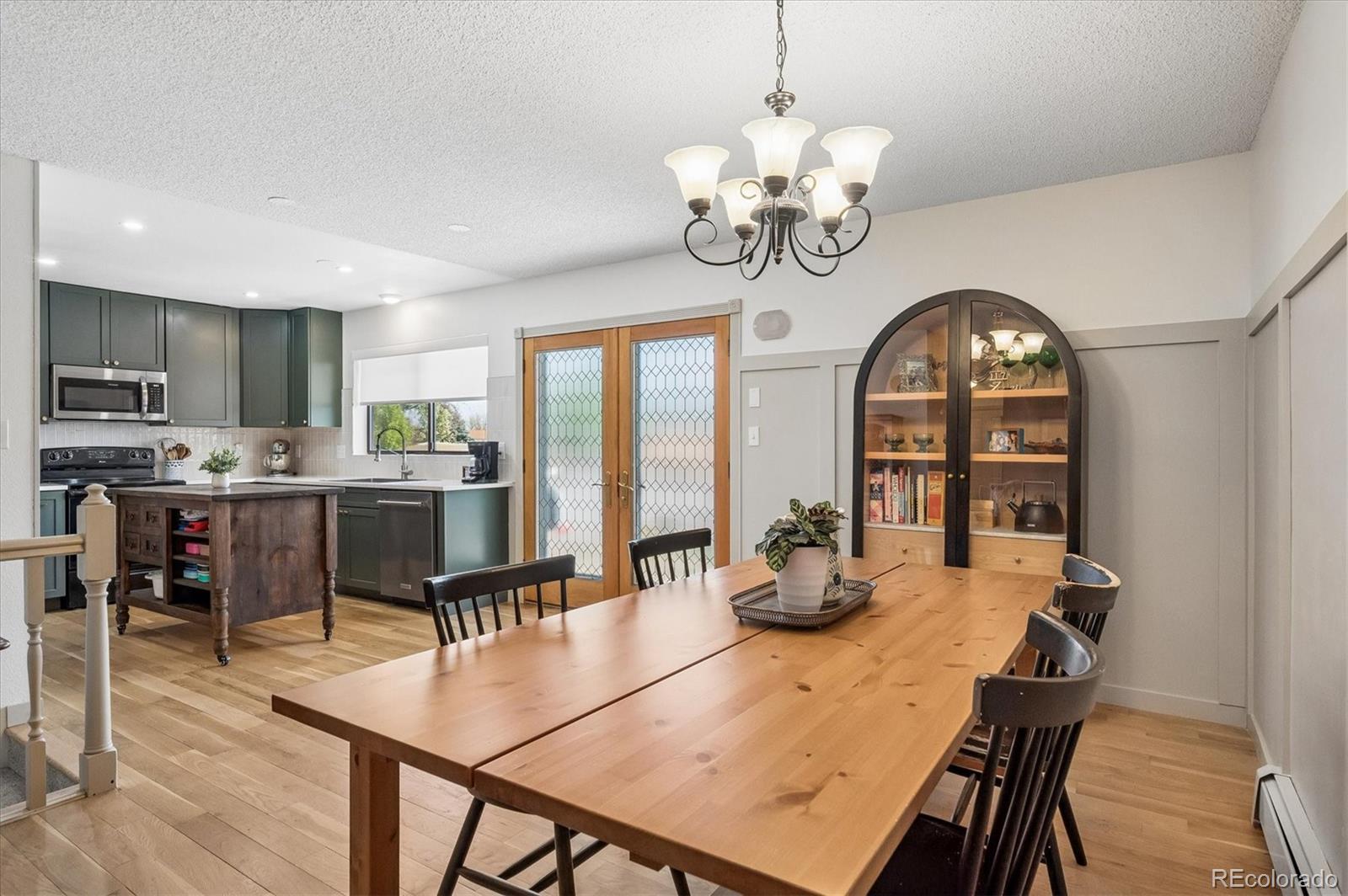 4654 South Union Street Morrison, CO 80465 - Photo 10 of 34 a dining room filled chandelier and wooden floor