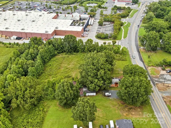 an aerial view of residential houses with outdoor space and trees all around