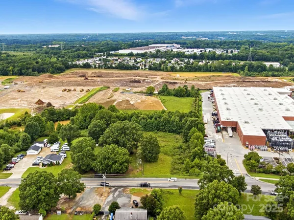 an aerial view of a city with lots of residential buildings ocean and mountain view in back