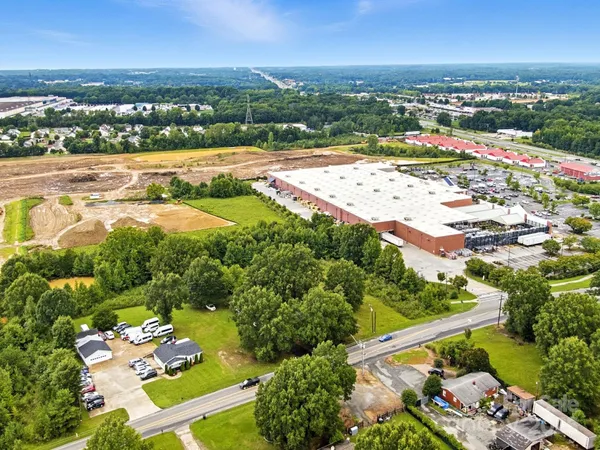 an aerial view of a city with lots of residential buildings ocean and mountain view in back